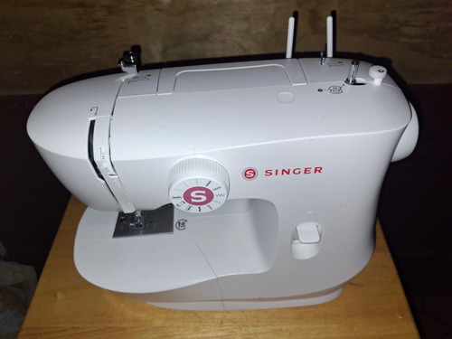 Full view of Singer MX60 Sewing Machine on wooden table showing stitch selector dial and threading system