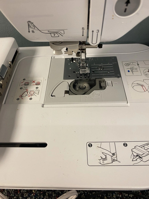 drop-in bobbin case, presser foot, and printed threading guides.
