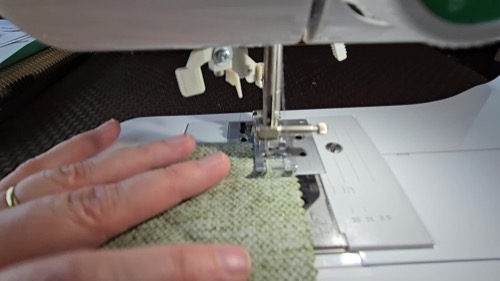 Fabric being guided beneath the Brother CE1155 presser foot