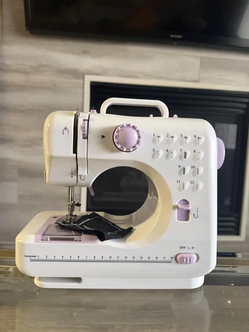 Qoosea white and purple mini sewing machine on a table