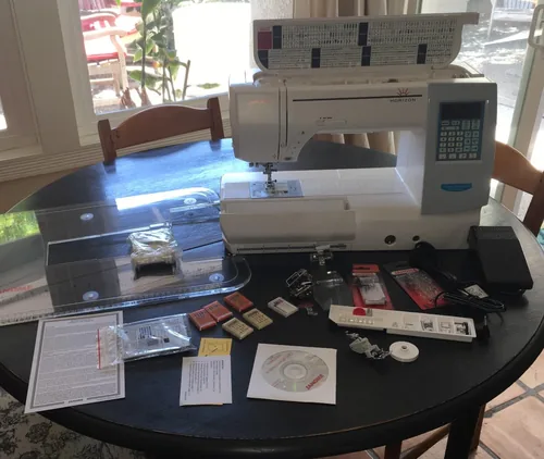 A customer’s Janome 8200QCP setup, with an extension table and accessories laid out beside the machine. Package contents can vary by seller.