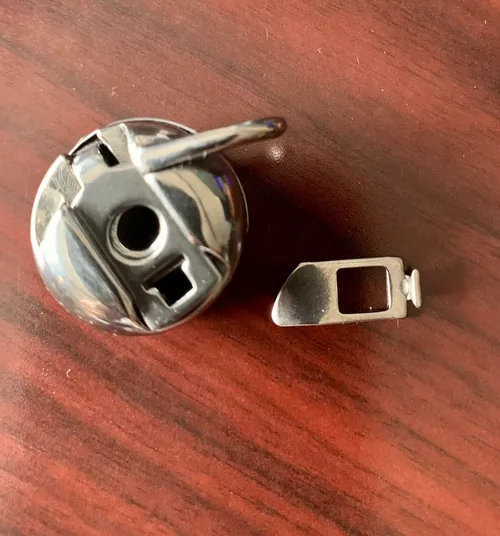 Bobbin-case parts photographed by an M3500 owner who reported that the holder broke after about a month.