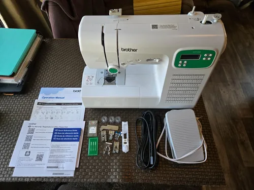 A customer’s Brother CE1155 with the manual, pedal and accessories arranged in front of the machine.