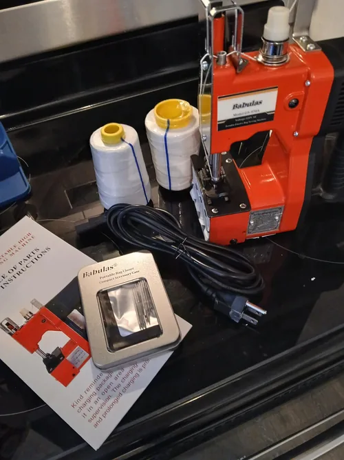 Babulas bag closer beside thread spools, power cord and accessory case
