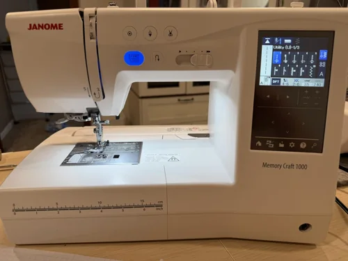 Janome Memory Craft 1000 on an owner’s sewing table, showing its controls and model label